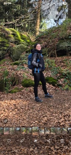 Eine Rezensentin trägt die schwarzen Tofana Eco Leggings bei einer Wanderung im Wald.