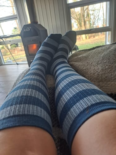 Anmelder slapper af med benene oppe iført stribede blå og grå Støttestrømper.