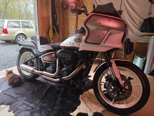 Reviewer's custom white motorcycle with a black and white Tour Step Up Saddlemen seat parked inside a garage.