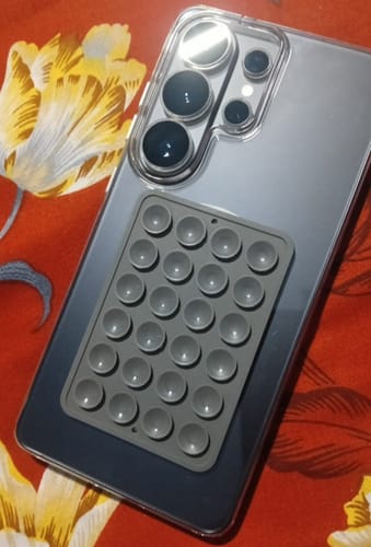 Reviewer's Anti Yellow Magsafe Clear Case on a phone, with a grey suction cup grip attached to the back.