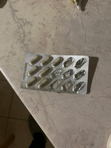 Ein Kunde zeigt eine teilweise aufgebrauchte Blisterpackung von OrthaVia intens Kapseln auf einer Arbeitsplatte.