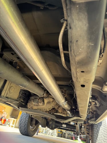 Customer's view from under their truck, showing the new muffler delete exhaust pipe installed.