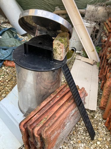 Client montrant le piège à rats intelligent installé sur un seau en métal avec sa rampe à l'extérieur.