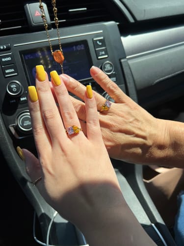 Customer and her mother wearing matching Toi Et Moi Birthstone Rings with pink and yellow stones.