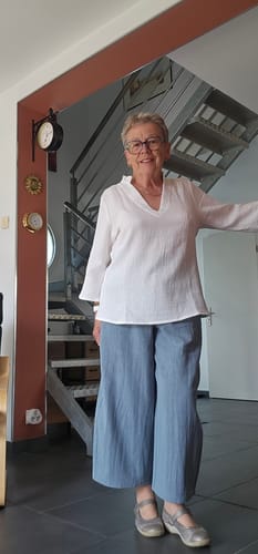 Cliente portant le pantalon Briac céladon à la coupe ample, qui apparaît bleuté sur la photo.