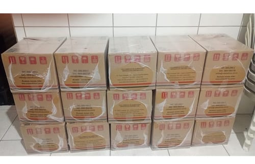 Cliente mostra as várias caixas da Cesta Básica Cedro empilhadas.