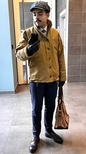 Reviewer in a full-length view wearing the tan USN N-1 Deck Jacket styled with a cap, shirt, and tie.