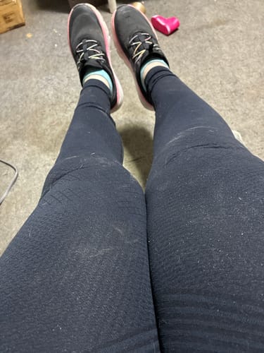 Reviewer's first-person view of their legs in the dark, textured Silix Anti-Cellulite Leggings.