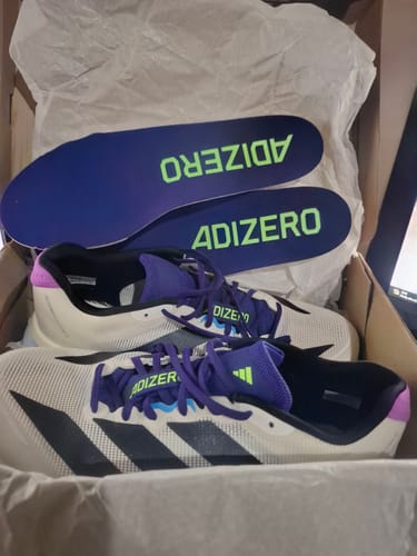 Customer's white and purple Adizero Boston 13 running shoes in a box, with the 'ADIZERO' insoles displayed on top.