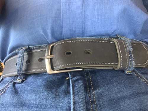 Reviewer showing The Suede belt in dark grey, worn with blue jeans.