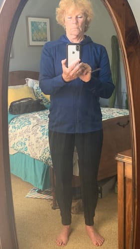 Reviewer standing in a mirror wearing the estate blue Ryann Hoodie to show its fit.