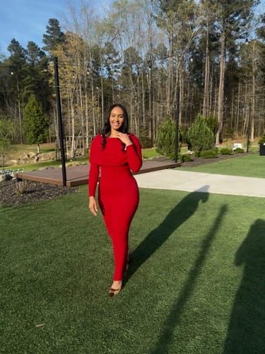 Reviewer standing outdoors in the fitted, red Boucle Knit Off-Shoulder Maxi Dress.