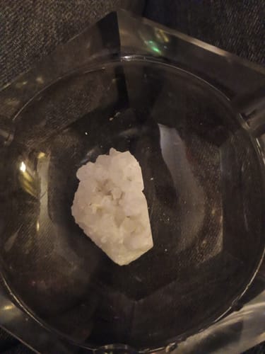 Customer's monthly white quartz crystal resting inside a small glass dish.