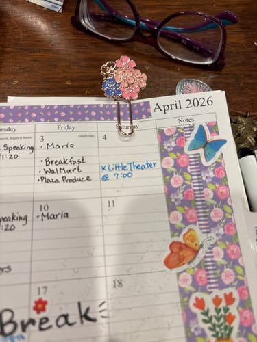 Customer's floral enamel Sakura Paper Clip attached to the top of an April planner page.