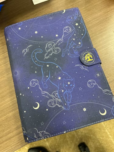 Customer's dark blue 2026 Dreambook + Planner cover with a celestial design featuring two panthers among stars.