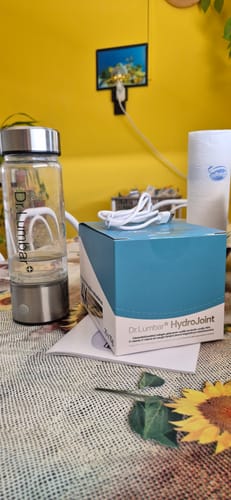 Vásárlói fotó a HydroJoint dobozáról és a hozzá tartozó üvegpalackról egy asztalon.