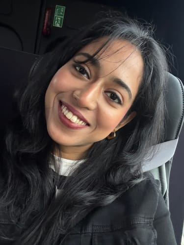 Customer smiling while wearing a small, gold hoop earring from the 5-piece accessory bundle.
