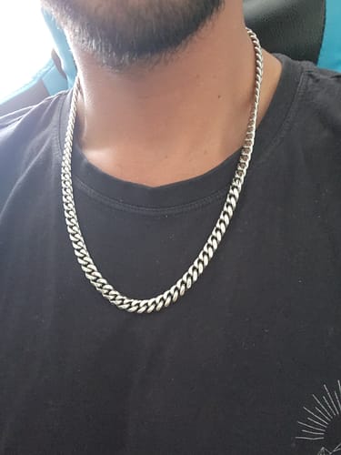 Cliente usando la Cadena Cuban Link de 8mm sobre una camiseta negra.