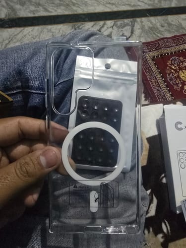Reviewer holds the clear Magsafe case for Galaxy S24 Ultra, showing its white magnetic ring.