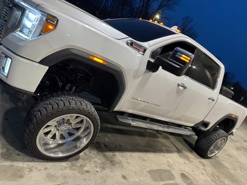 Customer's white truck with chrome spike lug nuts installed on a large chrome wheel.