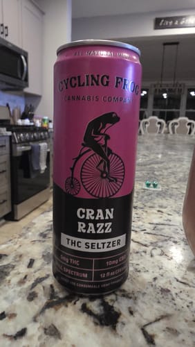 Customer's pink and black can of Cran Razz THC Seltzer sitting on a granite countertop in a kitchen.