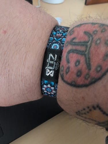 Close-up of a customer's wrist wearing the floral-patterned Grieving Is A Process Bracelet.