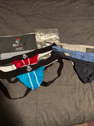 Customer's red and blue Modal Jockstraps from their order laid out on a gray surface with packaging.