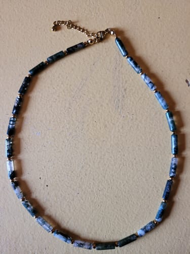 Photo d'un client : le collier Agate mousse avec des perles tubulaires vertes et blanches et un fermoir doré, posé sur une surface.