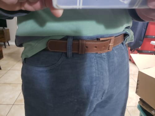 Close-up of a customer wearing the brown Heritage Bison belt, showing the fit with blue corduroy pants.