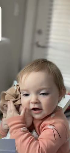 Close-up of a customer's baby cuddling the soft Personalized Melia Girl doll against her cheek.