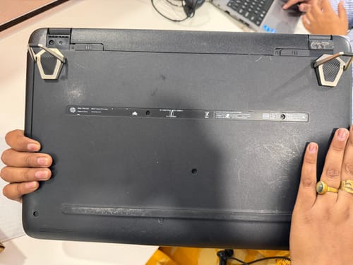 Customer holding the bottom of a laptop to show the two silver Casence AirStand supports attached and open.