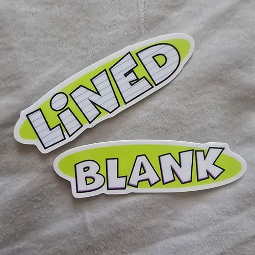 Reviewer's two custom vinyl stickers, one reading 'LINED' and the other 'BLANK' on a lime green background.