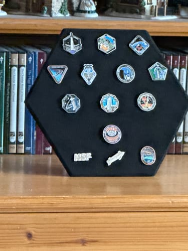 Customer's SpaceX Starship Flight Pin Collection arranged on the hexagonal black display mount, sitting on a shelf.