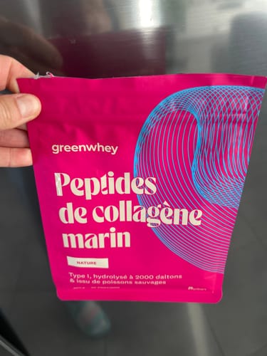 Client tenant le sachet rose vif de Peptides de Collagène Marin dans sa main.