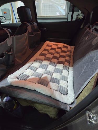 Customer's car seat hammock cover installed in the back of a vehicle, with a comfy dog bed placed on top.