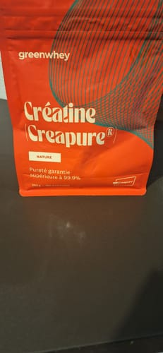 Vue rapprochée du sachet rouge de Créatine Creapure® d'un client posé sur une table.