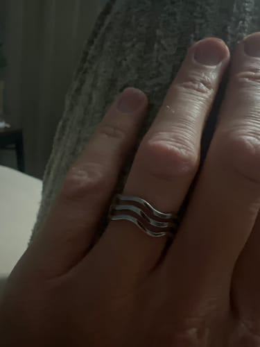 Close-up of a customer wearing the silver-toned Wave Trio Ring on their finger.