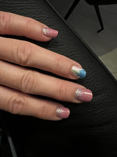 Kundin zeigt ihre Nägel mit der Easter Ombré Folie als Akzentnagel, kombiniert mit einer rosa-glitzernden Maniküre.