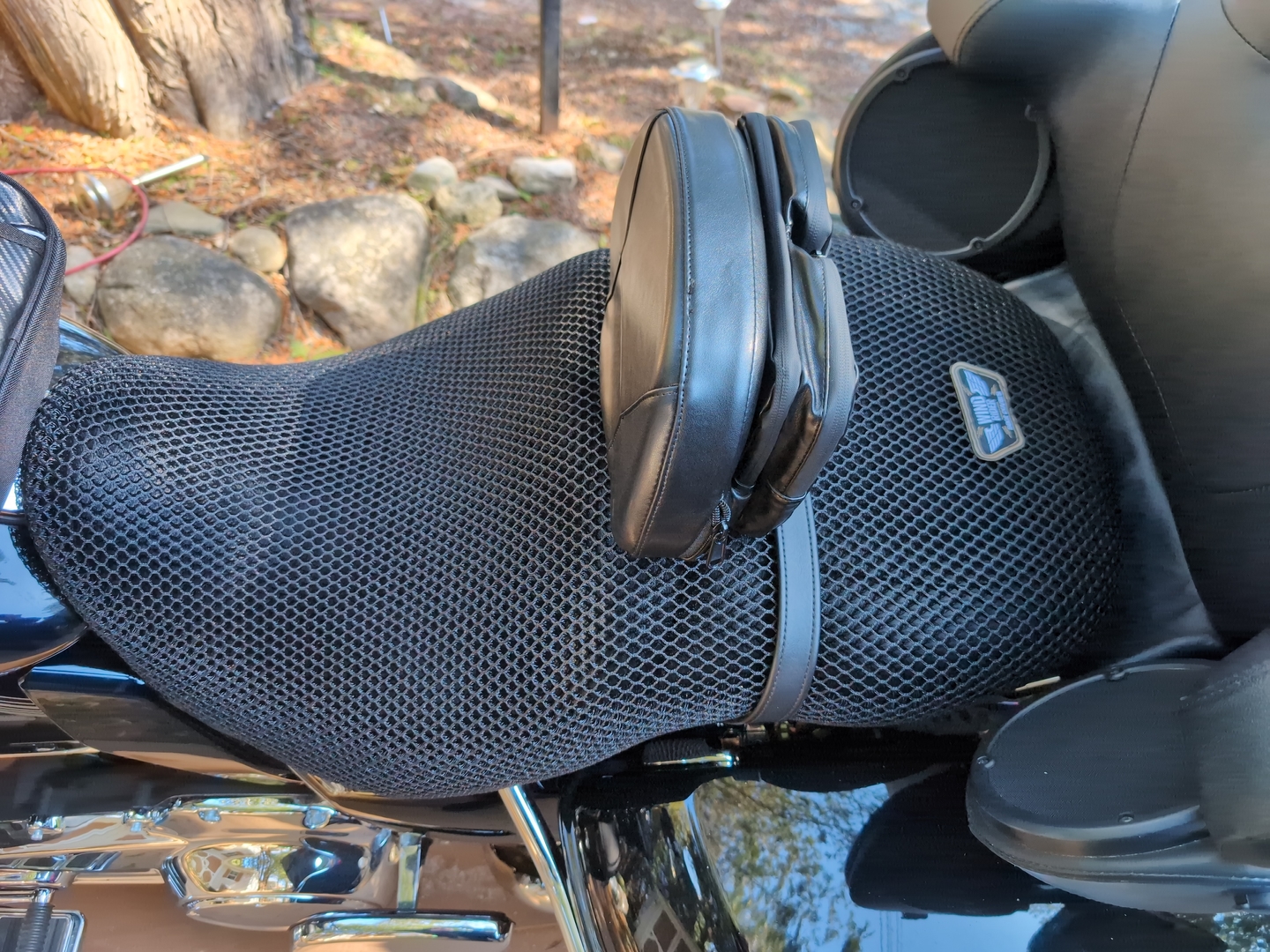 Close view of black factory vinyl motorcycle seat in direct sun showing heat-trapping sealed surface