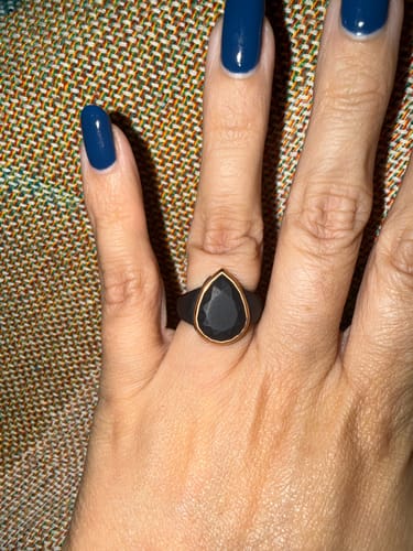 Close-up of a customer wearing the black Oversized Pear Collection silicone ring with a metal frame.