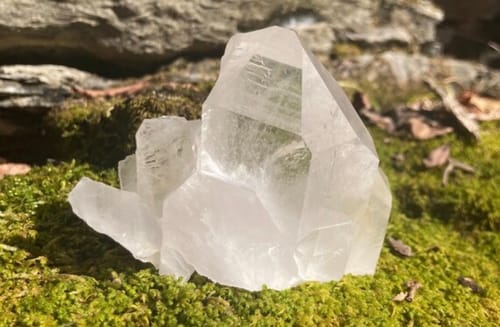 Customer's clear quartz cluster from the Monthly Crystal subscription sitting on bright green moss.
