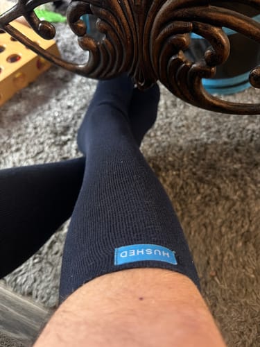 Close-up of a customer wearing the dark Performance Eucalyptus Compression Socks, showing the fit on their leg.