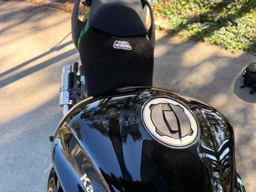 Reviewer's point-of-view of the black Wind Rider Seat Cover fitted on their motorcycle seat.