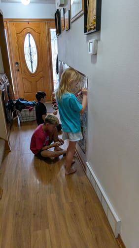 Customer's children in a hallway interacting with the WGSAD® | USA Edition search and discover poster.