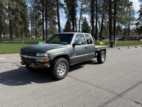 Customer's gray flatbed Chevy Silverado parked in a lot after installing the leveling lift kit.