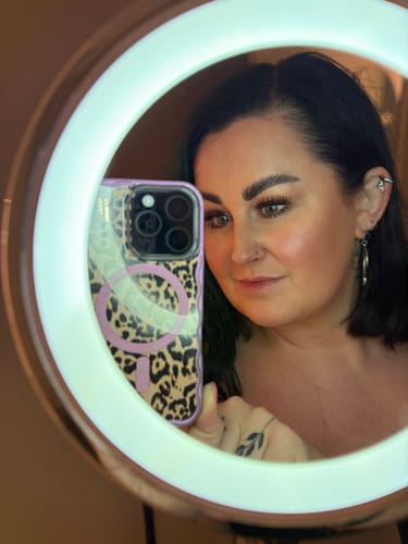 Kundin macht ein Selfie in einem beleuchteten Spiegel, das ihre vollen Doll Eye Edition Wimpern zeigt.