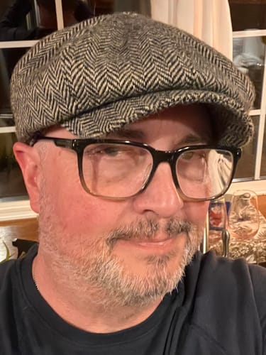 Close-up of a reviewer wearing the black and white herringbone Vintage Cap.