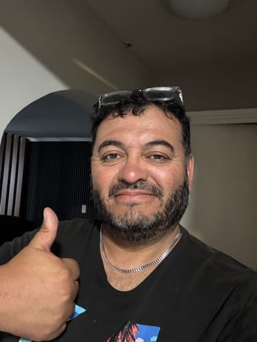 Cliente luciendo la Cadena Miami Cuban de 5mm sobre una camiseta negra y dando un pulgar arriba.
