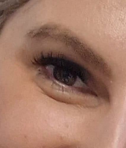 Nahaufnahme des Auges einer Kundin, die nach der Anwendung des BLACK TOOL SET volle, dunkle Wimpern zeigt.