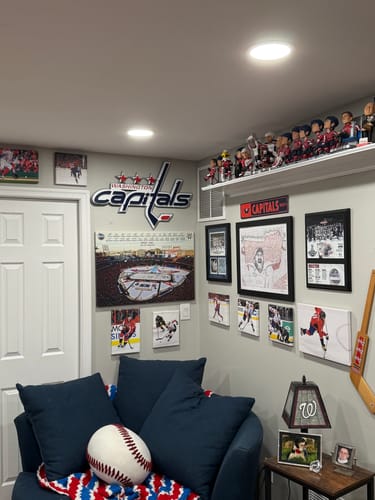 Customer's Washington Capitals 3D metal art on a wall in a sports-themed room, above a blue couch and other memorabilia.